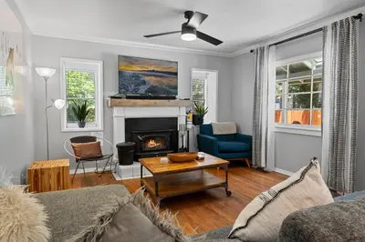 a living room with a couch and a fireplace at Happy Hours - Modern Cabin with Game Room and Peek-a-Boo Lake Views! in Big Bear Lake