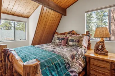 a bedroom with a bed and two windows at Ivvy Bear Lodge - Charming log cabin with Hot tub! Short walk to Village! in Big Bear Lake