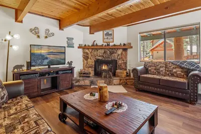 a living room with a couch and a fireplace at Ivvy Bear Lodge - Charming log cabin with Hot tub! Short walk to Village! in Big Bear Lake