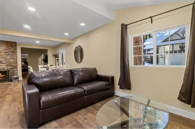 a living room with a leather couch and a glass table at Jaybird Lodge - Large and spacious home near the Lake and Village! in Big Bear Lake