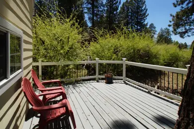 two red chairs sitting on a wooden deck at Jaybird Lodge - Large and spacious home near the Lake and Village! in Big Bear Lake