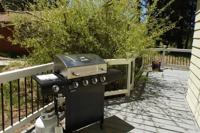 a grill sitting on a patio next to a fence at Jaybird Lodge - Large and spacious home near the Lake and Village! in Big Bear Lake