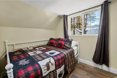 a small bedroom with a bed and a window at Jaybird Lodge - Large and spacious home near the Lake and Village! in Big Bear Lake