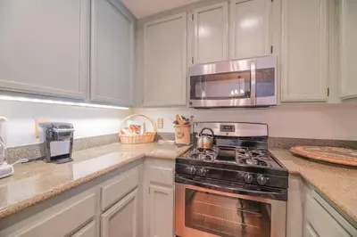 a kitchen with a stove and a microwave at Junipine Lakefront Condo - Walking distance to the lake! Less than 2 miles from the slopes! in Big Bear Lake