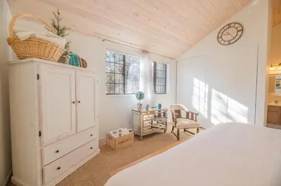 a bedroom with a white bed and a desk at Junipine Lakefront Condo - Walking distance to the lake! Less than 2 miles from the slopes! in Big Bear Lake