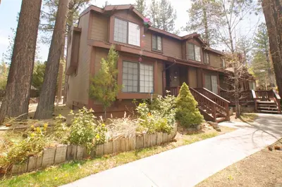 a house in the woods with a sidewalk at Junipine Lakefront Condo - Walking distance to the lake! Less than 2 miles from the slopes! in Big Bear Lake
