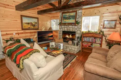 a living room with a couch and a fireplace at Knotty Knight- Walking distance to the lake as well as the Village! in Big Bear Lake