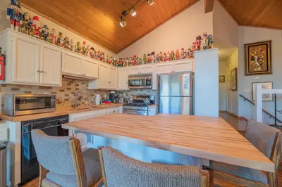 a kitchen with white cabinets and a wooden counter top at Lakefront Viking Oasis - Beautiful Viking Estates condo complex on the lake! in Big Bear Lake