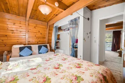 a bedroom with a large bed in a room with wooden ceilings at A Beary Happy Cabin - Charming gambrel style home within minutes of the Lake and The Village in Big Bear Lake