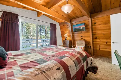 a bedroom with a bed and a large window at A Beary Happy Cabin - Charming gambrel style home within minutes of the Lake and The Village in Big Bear Lake