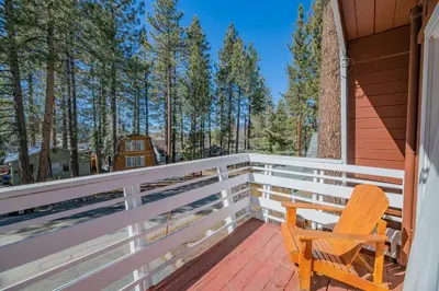 a rocking chair sits on the porch of a house at A Beary Happy Cabin - Charming gambrel style home within minutes of the Lake and The Village in Big Bear Lake
