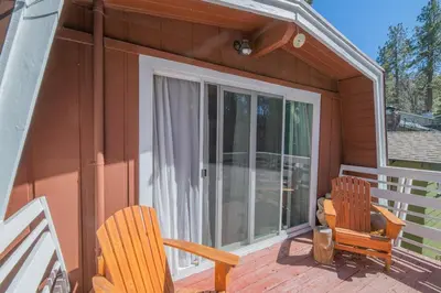 two chairs sitting on the porch of a house at A Beary Happy Cabin - Charming gambrel style home within minutes of the Lake and The Village in Big Bear Lake