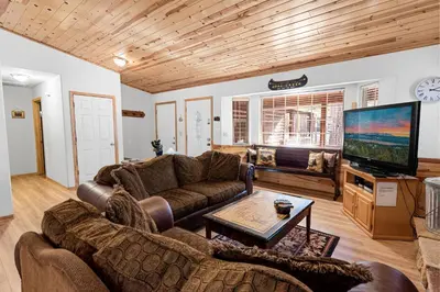 a living room with two couches and a flat screen tv at McWhinney The Pooh's Den - Everything you need for a memorable time with family! Pool Table! in Big Bear Lake