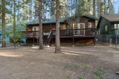 a large log cabin in the woods with a deck at McWhinney The Pooh's Den - Everything you need for a memorable time with family! Pool Table! in Big Bear Lake