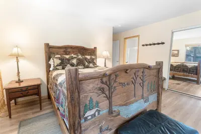 a bedroom with a large wooden bed in a room at McWhinney The Pooh's Den - Everything you need for a memorable time with family! Pool Table! in Big Bear Lake