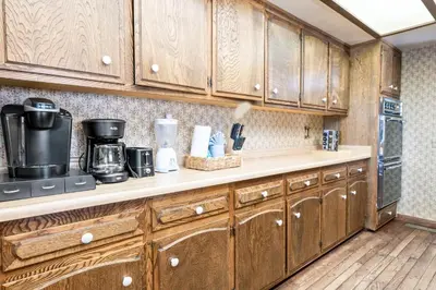a kitchen with wooden cabinets and a counter top at The Voges' Lake House - Amazing lake front house with a beautiful view and game room! in Big Bear Lake