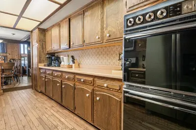 a kitchen with wooden cabinets and a stove top oven at The Voges' Lake House - Amazing lake front house with a beautiful view and game room! in Big Bear Lake