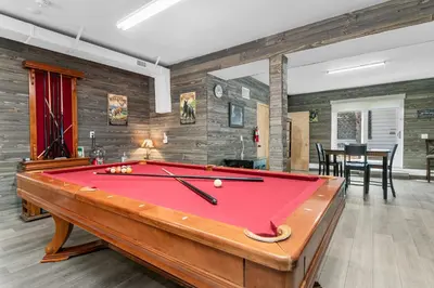 a pool table in the middle of a room at The Grizzlies Den - Log style cabin located in the desirable Fox Farm area! Games and arcade! in Big Bear Lake