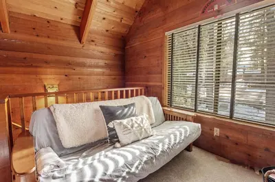 a room with a couch in a log cabin at The Lakehouse Cabin - Located close to the Lake! Hot Tub, Smart TV, and WiFi! in Big Bear Lake