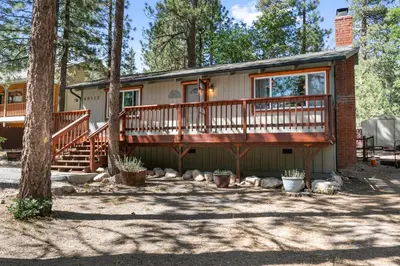 a house with a large deck on the side of it at The Oasis Chalet - Walking distance to The Village, The Lake, and Alpine Slide! in Big Bear Lake