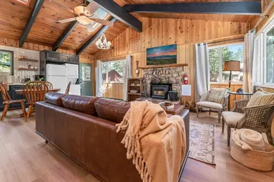 a living room with a leather couch and a fireplace at The Oasis Chalet - Walking distance to The Village, The Lake, and Alpine Slide! in Big Bear Lake