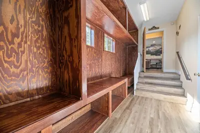a hallway with wood paneling and stairs in a house at The Bear Den - DREAM LOCATION WALKING DISTANCE TO LAKE AND VILLAGE! in Big Bear Lake