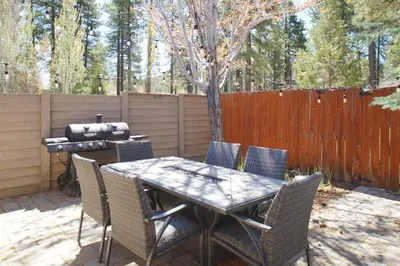 a patio with a table and chairs and a grill at The Bear Den - DREAM LOCATION WALKING DISTANCE TO LAKE AND VILLAGE! in Big Bear Lake