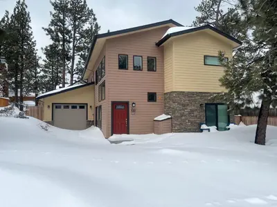 a house with a red door in the snow at Modern Times - Amazing place with super open concept! Jet tub! in Big Bear Lake