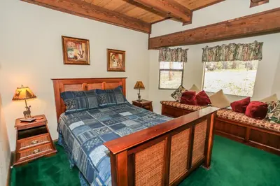 a bedroom with a bed and two benches in it at Summit Adventure - Beautiful, spacious and quiet home! Foosball, pool and poker table! Jet tub! in Big Bear Lake