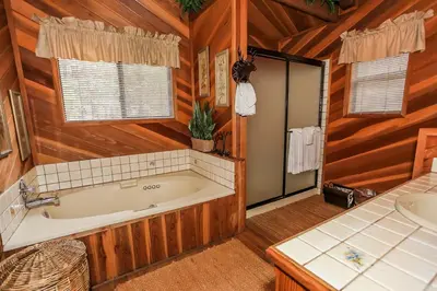 a bathroom with a bath tub and a sink at Summit Adventure - Beautiful, spacious and quiet home! Foosball, pool and poker table! Jet tub! in Big Bear Lake