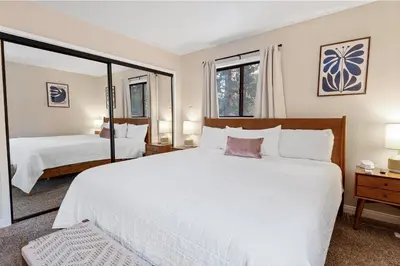 a bedroom with a large white bed and two windows at Badger Den - Located in the heart of the village in Big Bear Lake