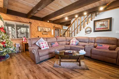 a living room with a couch and a christmas tree at Summit Mountain Lodge - Amazing location just down the street from Snow Summit! in Big Bear Lake