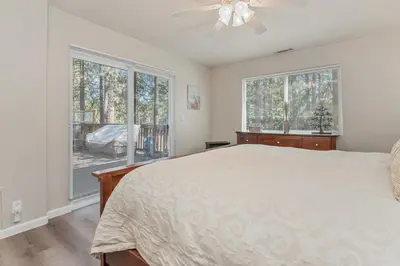 a bedroom with a bed and two windows at Serenity Knoll - Comfortable, spacious single-level cabin! Newly remodeled! Hot Tub and Pool Table! in Big Bear Lake
