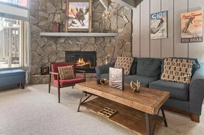 a living room with a couch and a fireplace at Ski-In Ski-Out Summit Townhouse- Perfect mountain getaway with views of the forest and Snow Summit! in Big Bear Lake