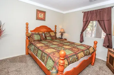 a bedroom with a bed and a window at Rincon Cabin - Close to the lake with a huge fenced in yard! Hot tub and deck with barbecue! in Big Bear Lake