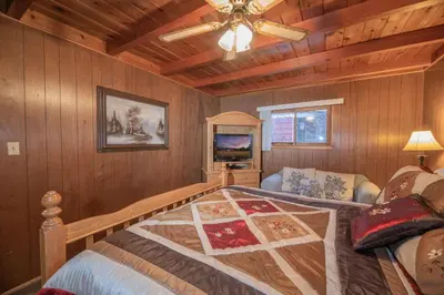 a bedroom with a bed and a ceiling fan at Sauer Suite - Cozy, rustic cabin walking distance to Holloway's Marina with peek-a-boo lake views! in Big Bear Lake