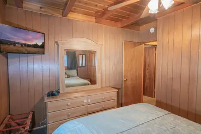 a bedroom with a bed and a large mirror at Sauer Suite - Cozy, rustic cabin walking distance to Holloway's Marina with peek-a-boo lake views! in Big Bear Lake