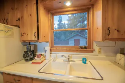 a kitchen counter with a sink and a window at Sauer Suite - Cozy, rustic cabin walking distance to Holloway's Marina with peek-a-boo lake views! in Big Bear Lake