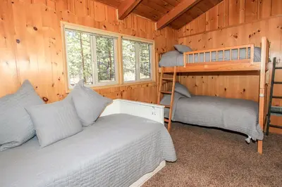 a bedroom with two bunk beds in a cabin at Owl Cabin - Sierra style cabin located on a quiet road in Fawnskin and backs up to National Forest! in Fawnskin