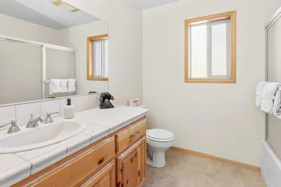 a white bathroom with a sink and a toilet at Papa Bear's Hideout - Dream Getaway with Hot Tub and Game Room! in Big Bear Lake