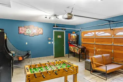 a room with a foosball table and a video game at Papa Bear's Hideout - Dream Getaway with Hot Tub and Game Room! in Big Bear Lake