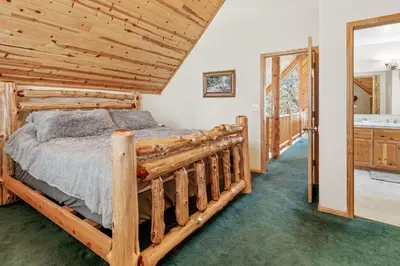 a bedroom with a wooden bed in a room at Papa Bear's Hideout - Dream Getaway with Hot Tub and Game Room! in Big Bear Lake