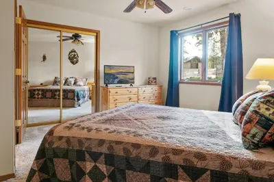 a bedroom with a bed and a dresser and a mirror at North Shore Lakefront - Spacious Lakefront with Hot Tub, & Game Room in Fawnskin