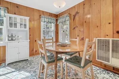 a dining room with a table and chairs and wooden walls at Oak Nesting - Great chalet style cabin at the end of the street with rustic stone gas log fireplace! in Big Bear Lake
