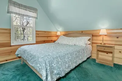 a bedroom with a bed and a window at Oak Nesting - Great chalet style cabin at the end of the street with rustic stone gas log fireplace! in Big Bear Lake