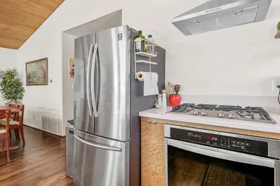 a kitchen with a stainless steel refrigerator and a stove at Nightcap Lodge- HOT TUB WITH BREATHTAKING MOUNTAIN VIEWS! in Fawnskin