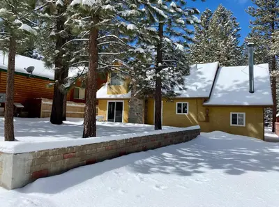 a house with snow on the ground in front of it at Mountain Fever - Offers a Foosball Table and Barbecue Grill and a large back deck! in Big Bear Lake