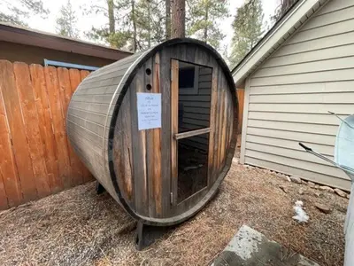 a large wooden boat sitting outside of a house at Boulder Bay Bungalow - Updated mountain retreat with hot tub, game table, and sauna! in Big Bear Lake