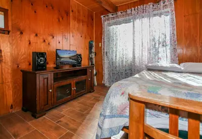 a bedroom with a bed and a window at Bear 'n Tree - Cozy cabin near the Village in Big Bear Lake