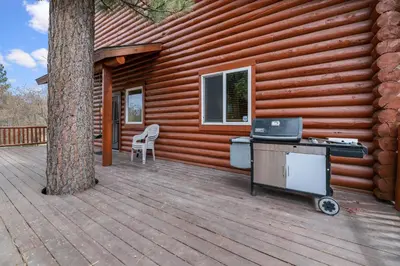 a wooden deck with a house with a stove on it at Bear Bait - Lots of games, televisions, beds, telescope, and 3 bathrooms in Big Bear Lake